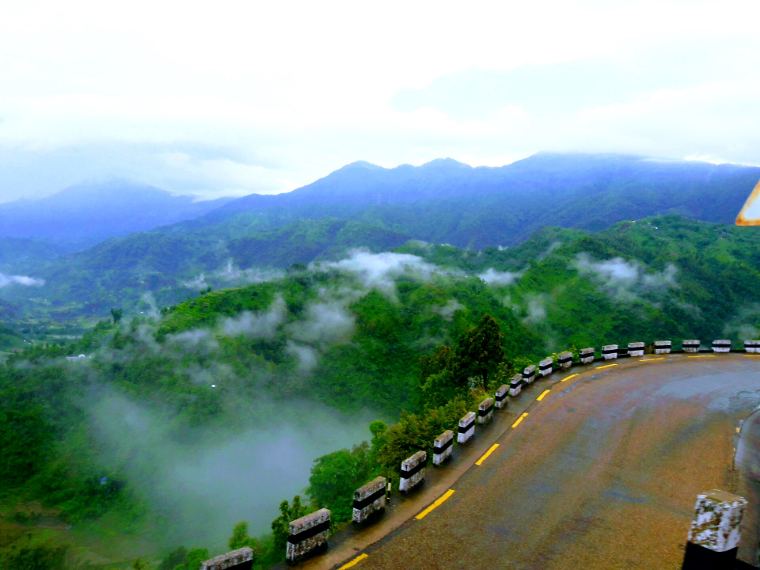 A winding highway above misty green hills
